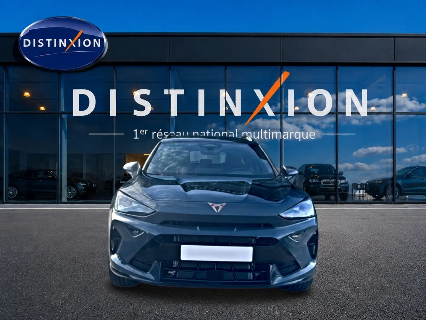 Vue avant d'un CUPRA Formentor bleu fjord 2026 avec logo distinctif et phares LED allumés devant un showroom Distinxion.