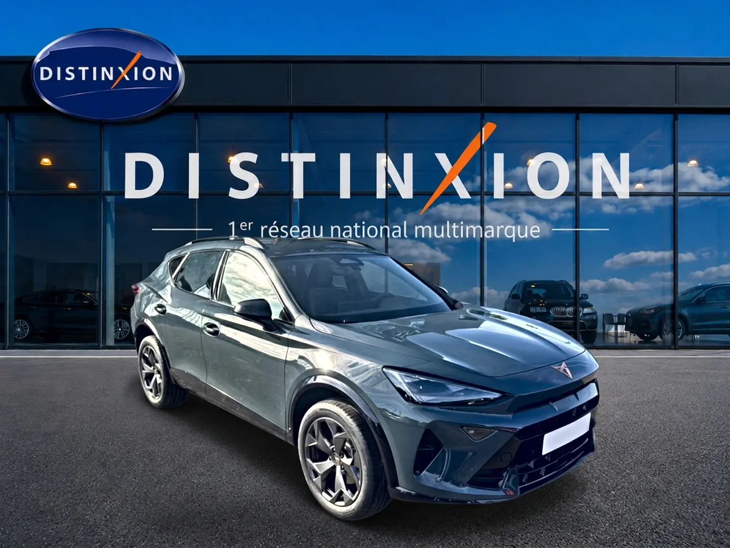 Vue 3/4 avant droit d'un SUV CUPRA Formentor 1.5 etsi hybrid bleu fjord avec jantes 18 pouces devant un showroom Distinxion.