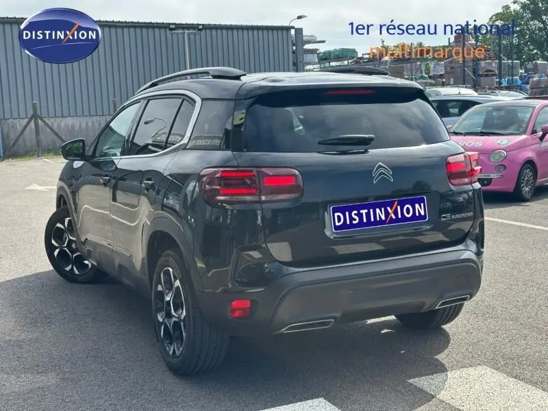 Vue 3/4 arrière droite d'un Citroën C5 Aircross noir Perla Nera 2025 avec feux arrière LED et jantes alliage.