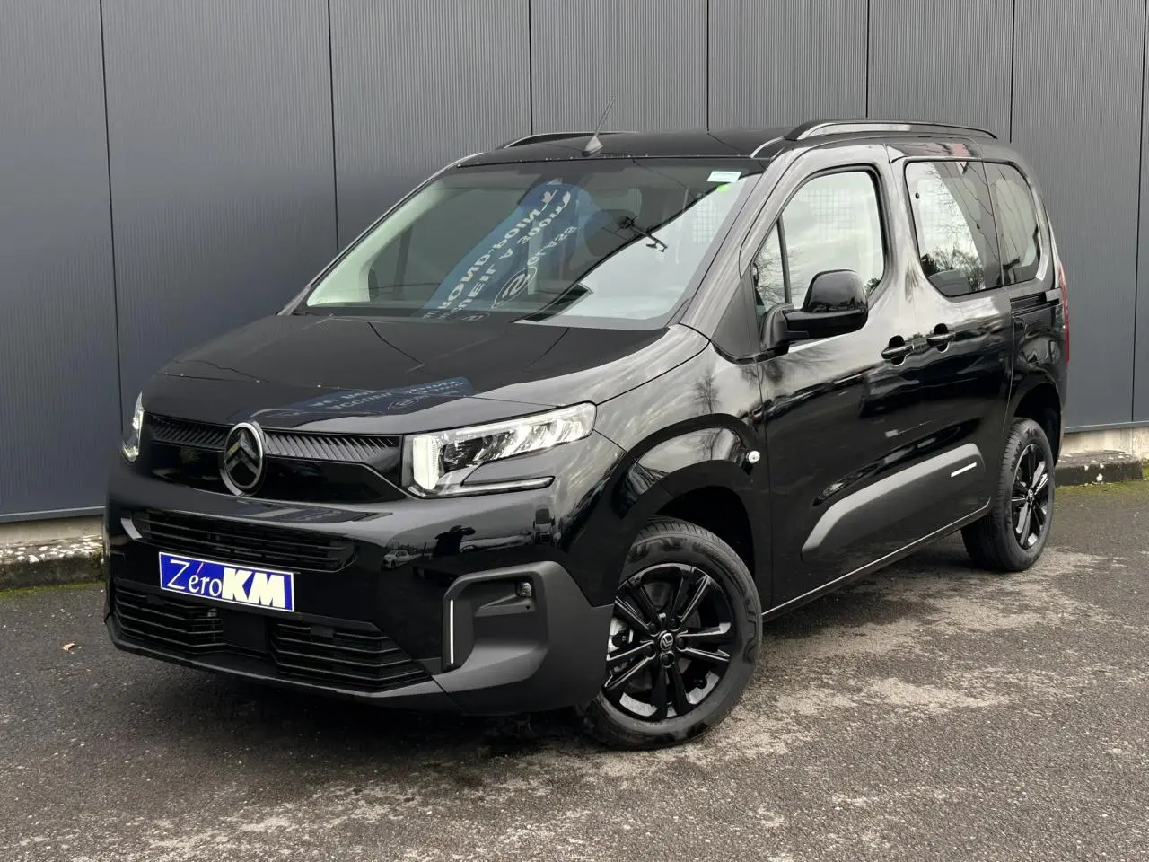 Citroën Berlingo Multispace noir Perla en 3/4 avant droit, avec jantes alliage noires et barres de toit.