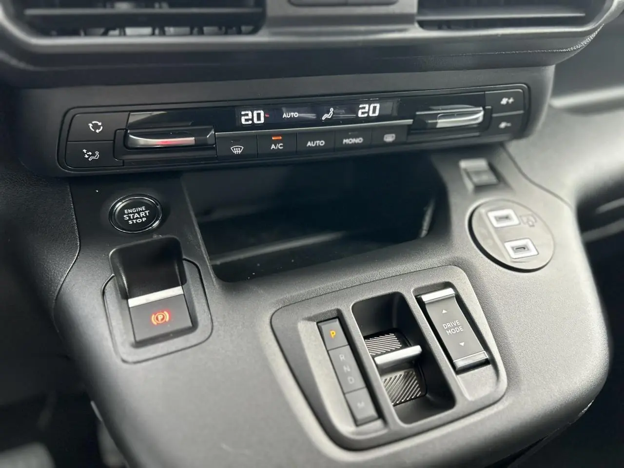 Gros plan sur la console centrale noire du Citroën Berlingo Multispace 2025 avec commandes climatisation et boîte auto.