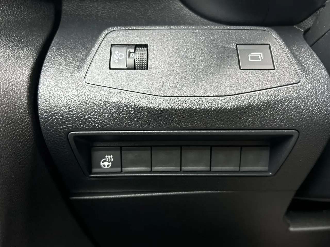 Gros plan sur les commandes noires du tableau de bord du Citroën Berlingo Multispace 2025, avec bouton de chauffage volant.