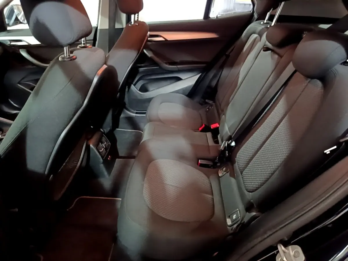 Vue intérieure côté droit des sièges arrière noirs du BMW X2 sDrive18i Lounge DKG7 2023, avec ceintures et appuie-têtes visibles.