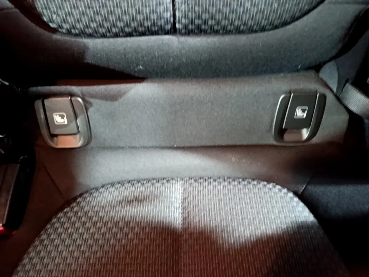 Détail des commandes Isofix sur la banquette arrière en tissu gris du BMW X2 sDrive18i Lounge noir 2023.