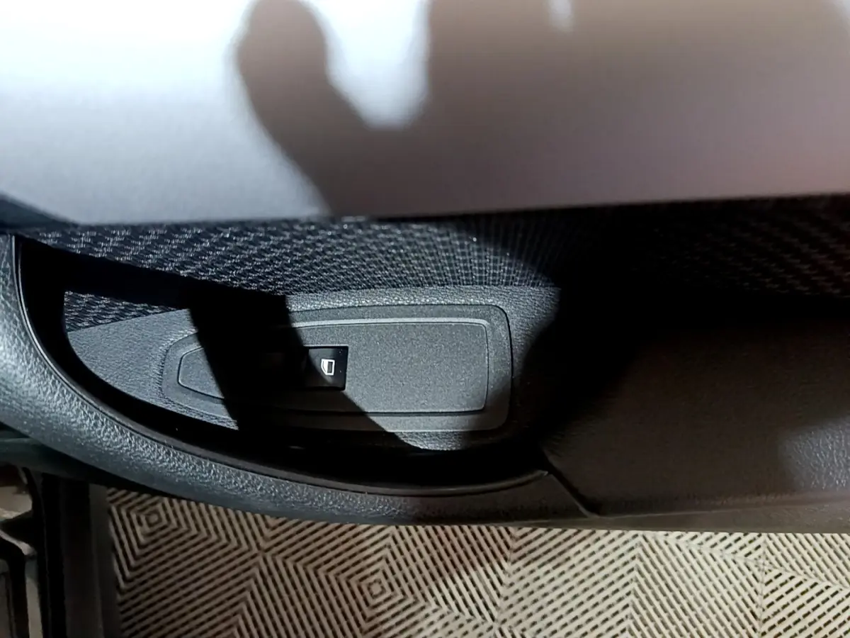 Détail du bouton de verrouillage des vitres sur la porte côté conducteur d’un BMW X2 noir 2023.