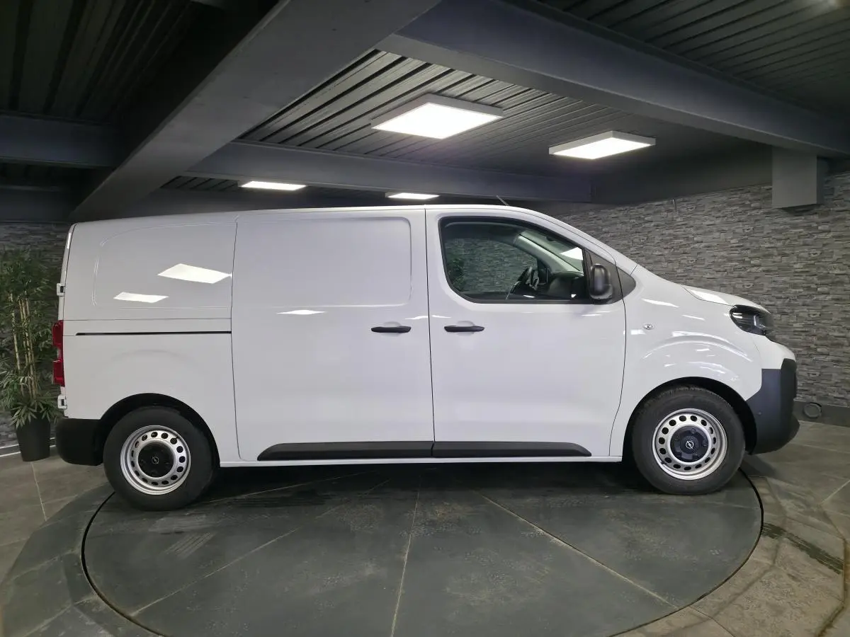 Vue latérale droite d’un Opel Vivaro blanc 2025 avec portes coulissantes et jantes tôles grises en intérieur.