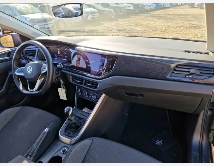 Vue intérieure côté conducteur de la Volkswagen Polo 1.0 TSI 95 VW Edition 2024, avec tableau de bord numérique et boîte manuelle.