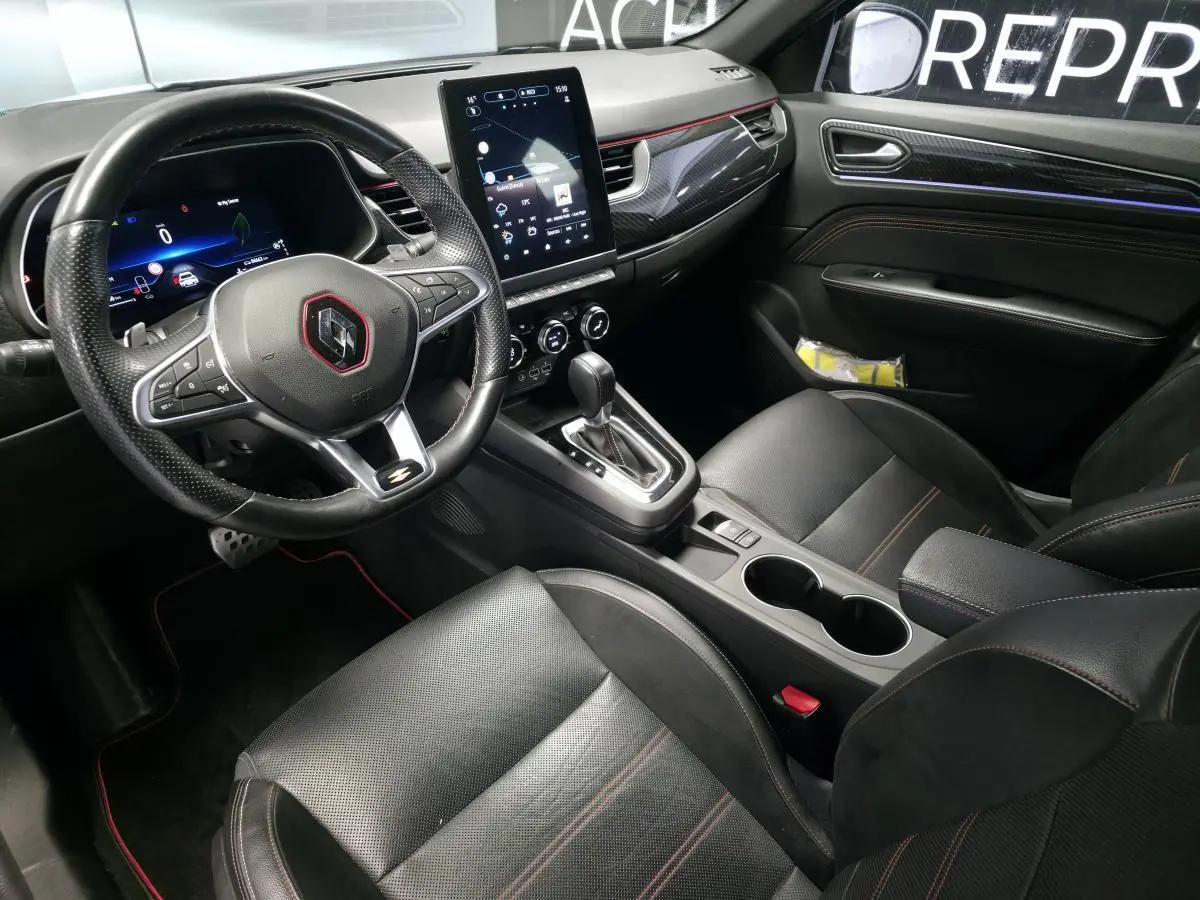 Intérieur noir du Renault Arkana R.S. Line 2023, vue côté conducteur, volant sport, écran tactile vertical et sellerie cuir/suédine.