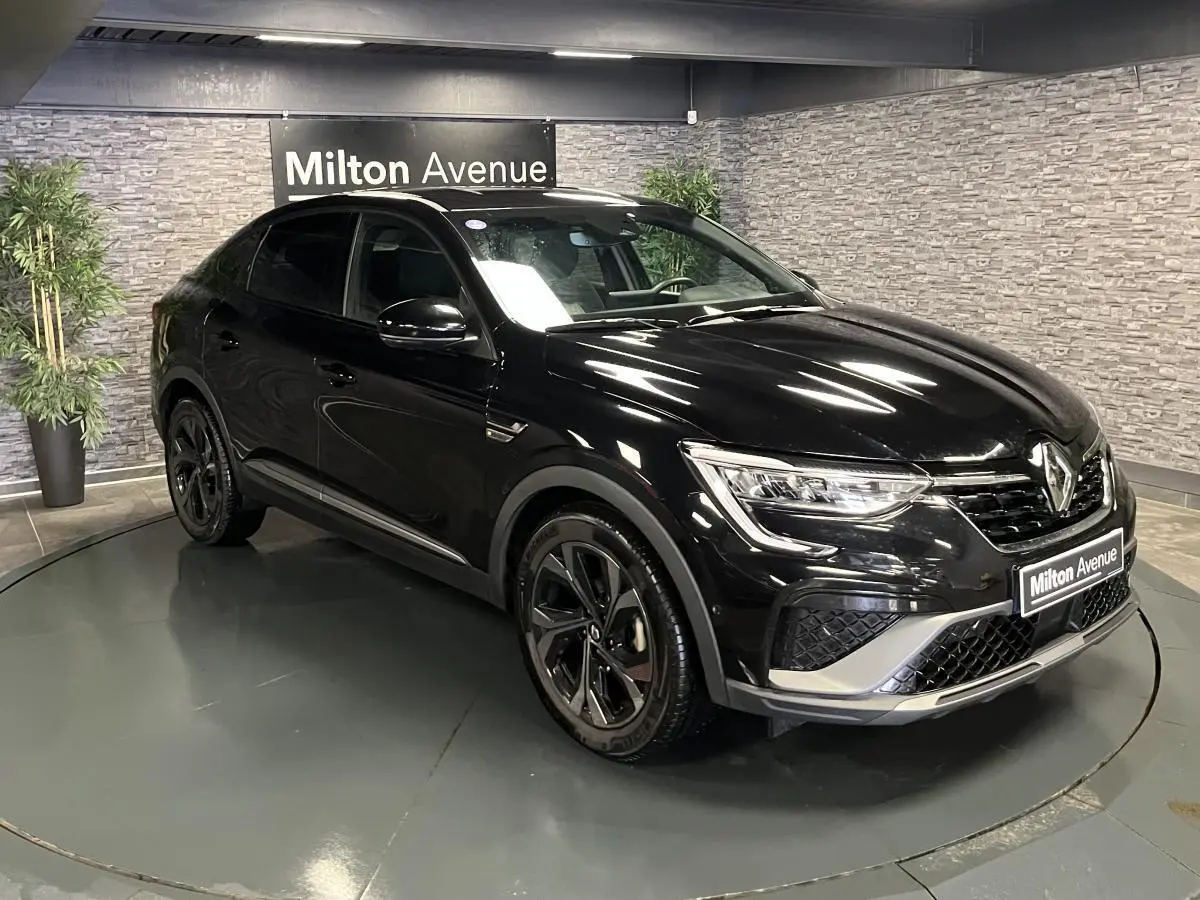 Renault Arkana R.S. Line noir métal en 3/4 avant droit, avec jantes noires et détails gris métallisé sport.