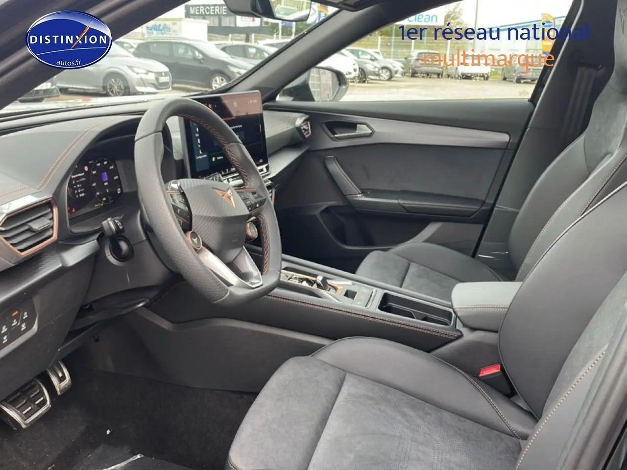 Intérieur avant du CUPRA Formentor 2.0 TDI 2025, sièges sport gris, volant sport avec surpiqûres orange et écran tactile central.