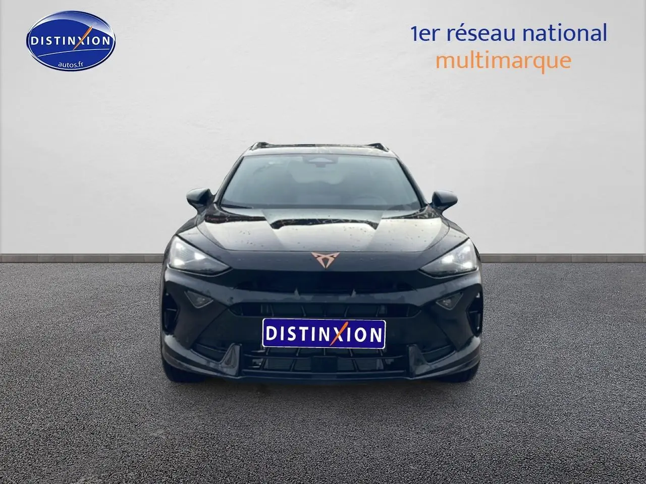 Vue frontale d'un CUPRA Formentor noir 2025 avec logo cuivré et phares LED allumés sur fond neutre.