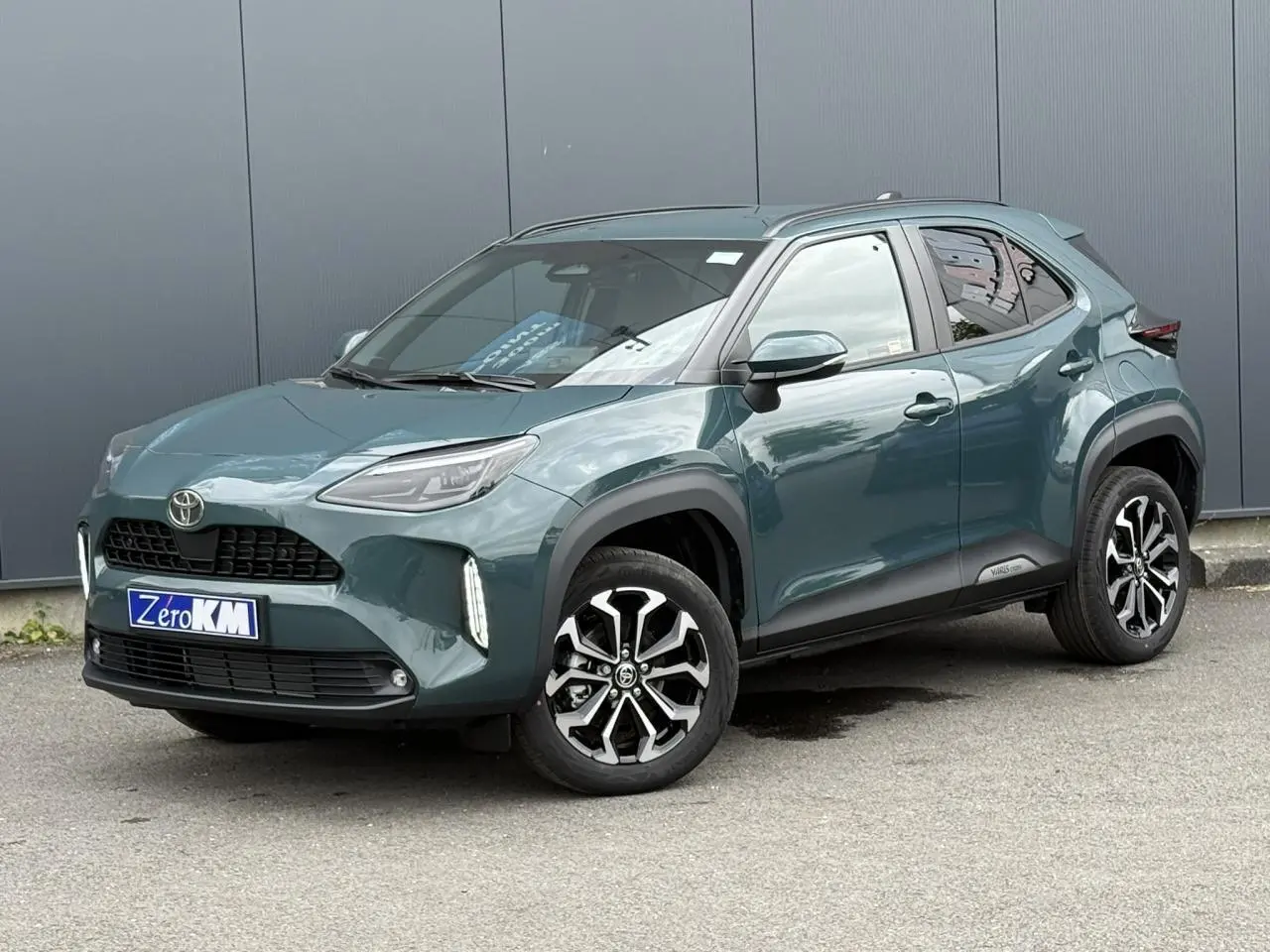 Toyota Yaris Cross vert impérial en 3/4 avant droit, avec jantes alliage bicolores et feux LED verticaux.