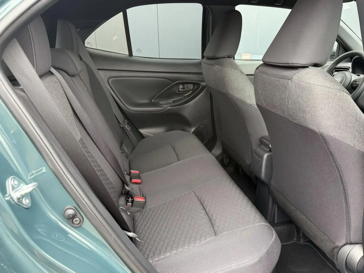 Vue intérieure côté gauche des sièges arrière gris du Toyota Yaris Cross 1.5 Hybrid 116 Design Vert Imperial.
