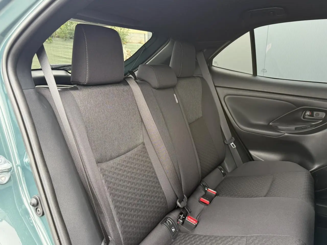 Vue intérieure du côté arrière droit de la banquette noire du Toyota Yaris Cross 1.5 Hybrid 2026 en Vert Imperial.