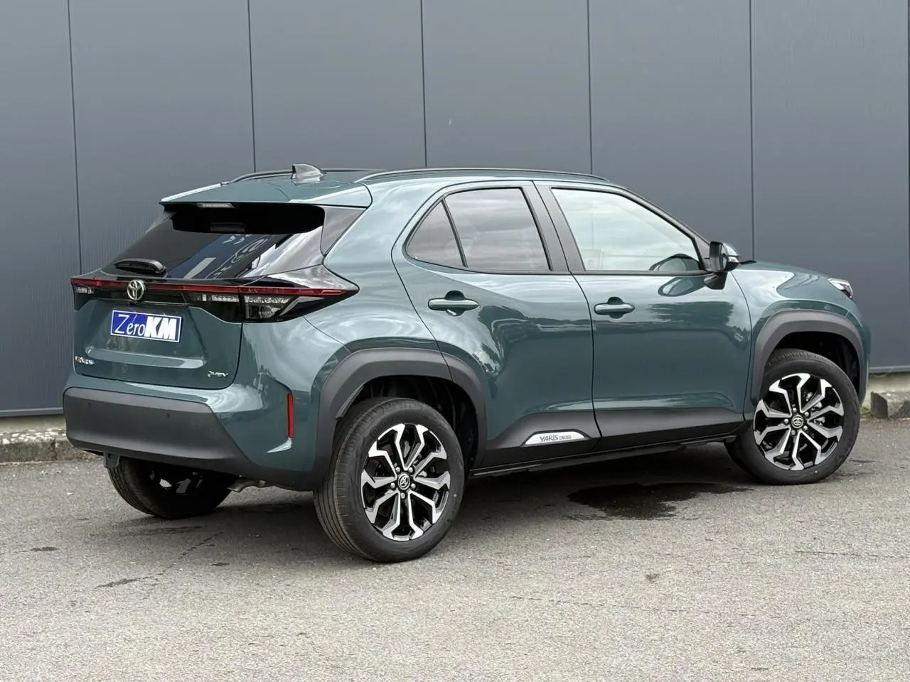 Toyota Yaris Cross 1.5 Hybrid vert impérial, vue 3/4 arrière droit avec jantes noires et toit noir.