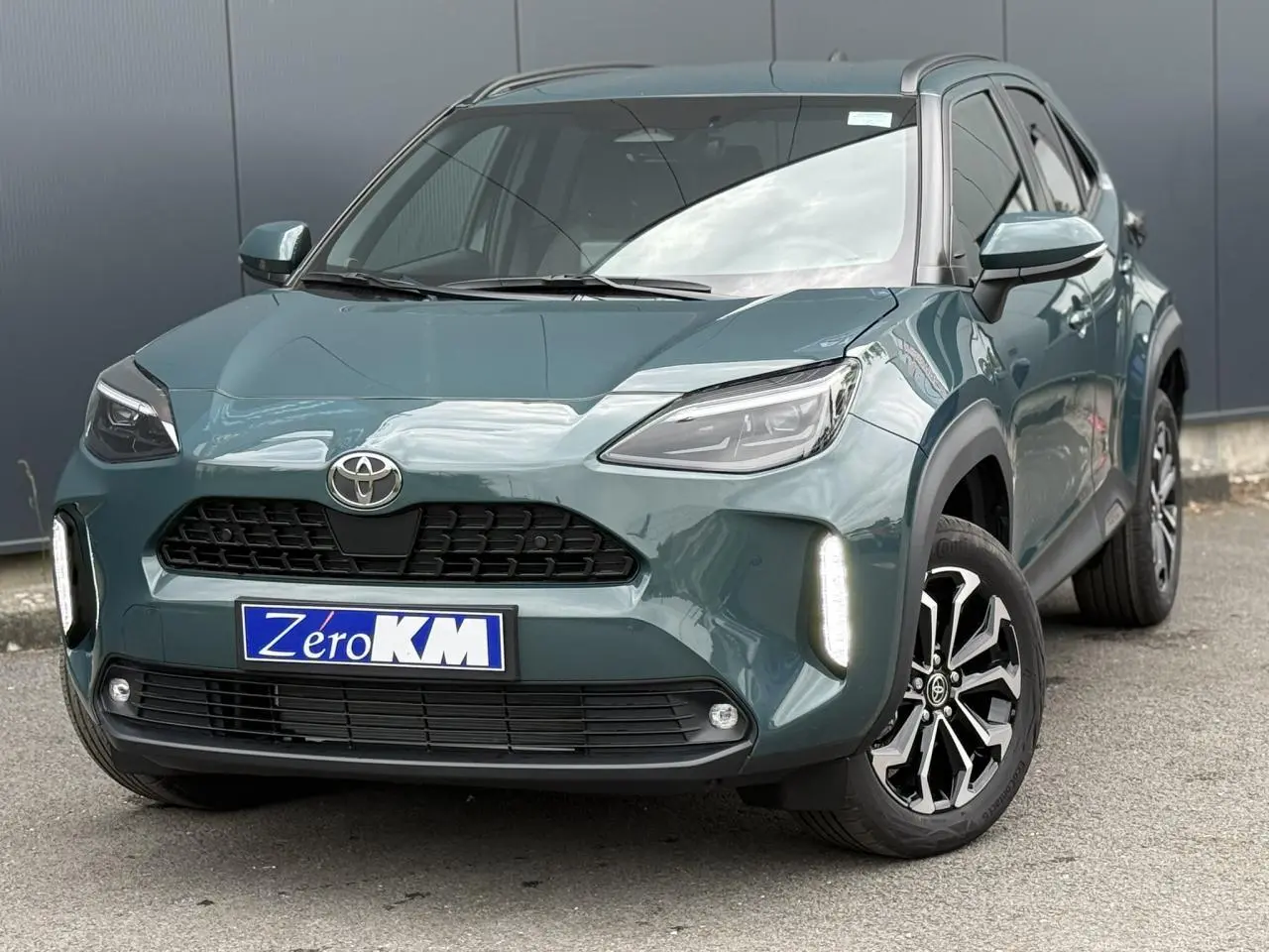 Toyota Yaris Cross 1.5 Hybrid vert Imperial vue 3/4 avant avec feux LED allumés et jantes noires.