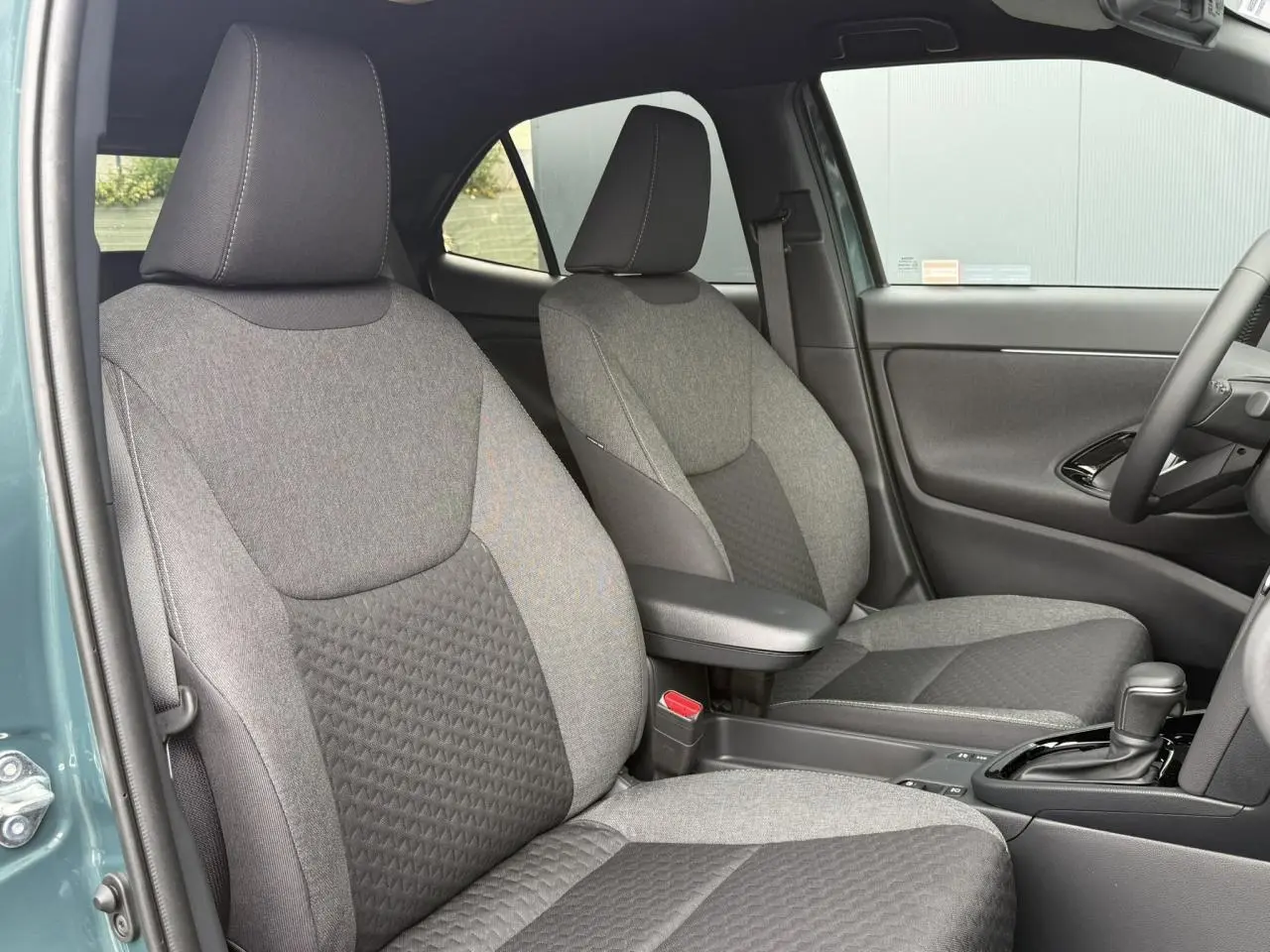 Vue intérieure côté droit des sièges avant gris foncé et clair du Toyota Yaris Cross 1.5 Hybrid 116 Design 2026.