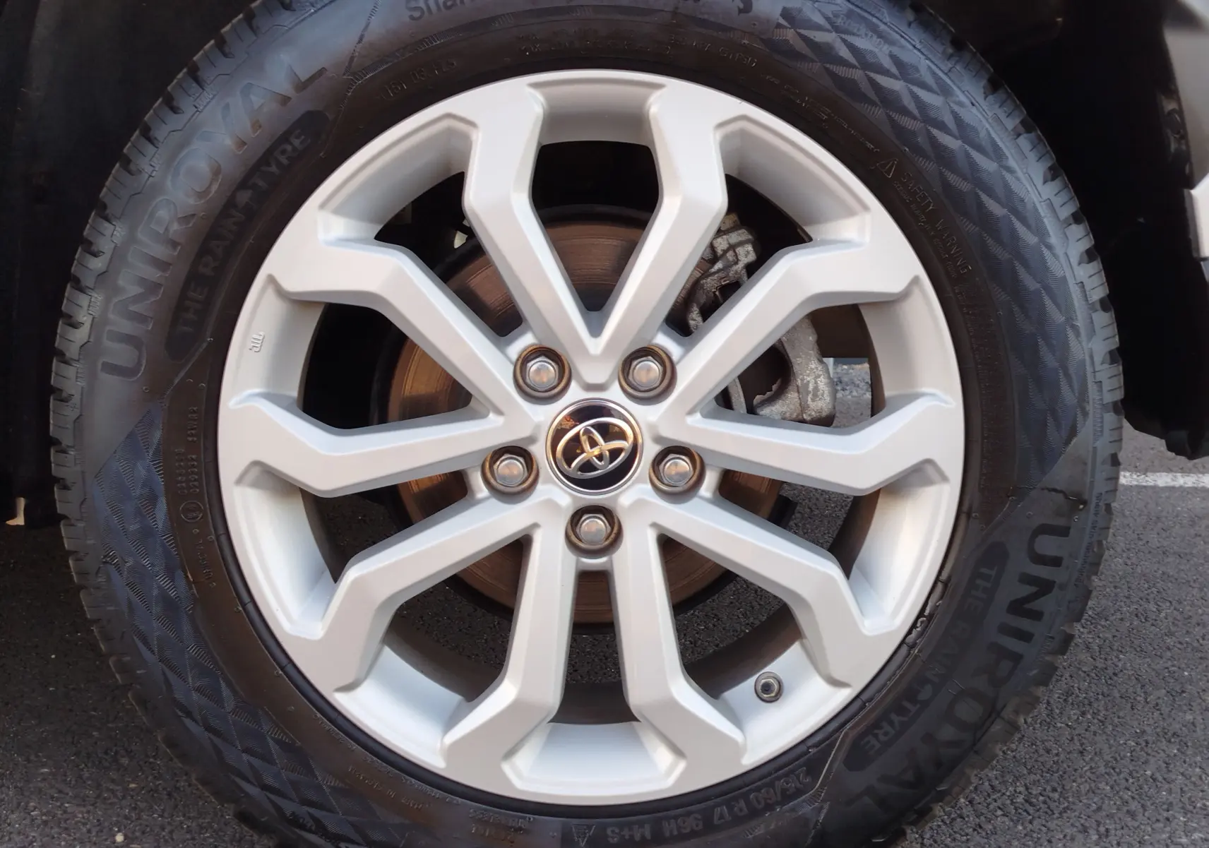 Gros plan sur la jante alliage argentée du Toyota Corolla Cross 1.8 140ch Dynamic avec logo Toyota au centre.