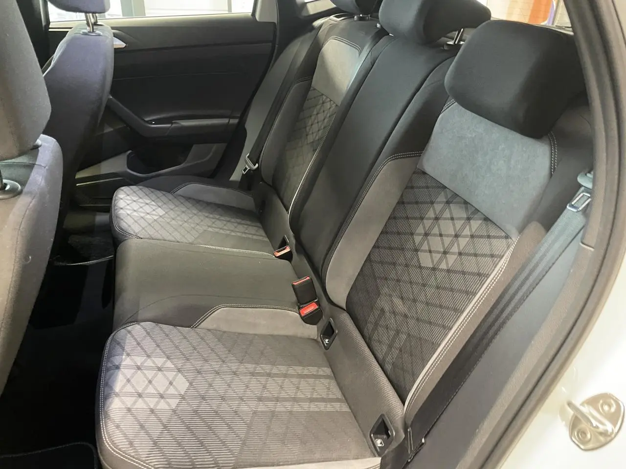 Vue côté droit de la banquette arrière en tissu gris et noir de la Volkswagen Polo 2024 R-Line blanche.