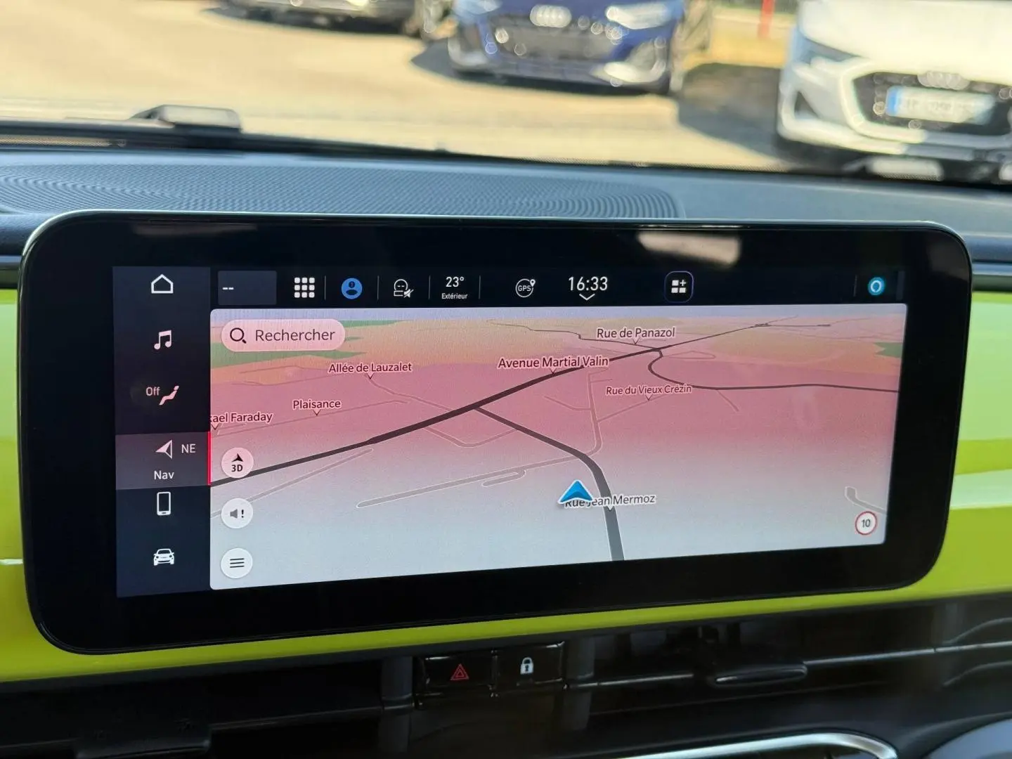 Écran tactile central affichant la navigation dans une Fiat 500 électrique jaune vue de l'habitacle.