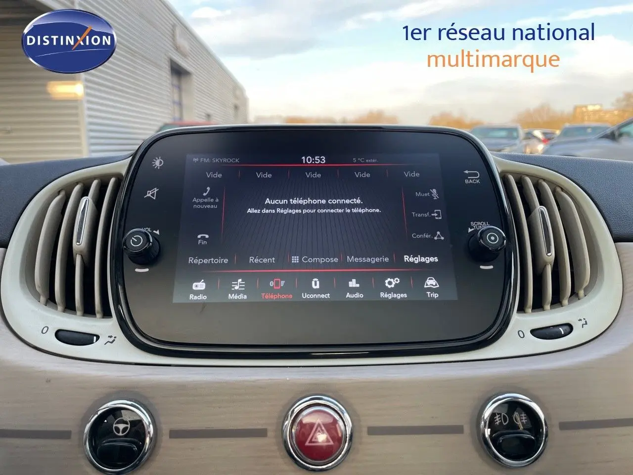 Écran tactile central avec interface multimédia allumée dans l’habitacle clair d’une Fiat 500 blanche.