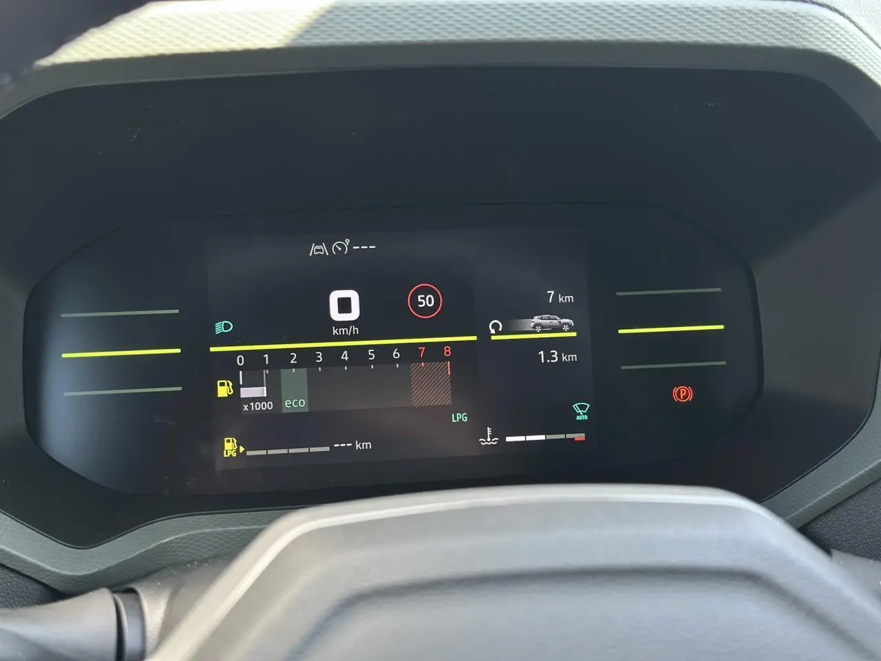 Tableau de bord digital 7 pouces du Dacia Duster ECO-G 100 Extrême affichant vitesse et alertes, vue frontale intérieure.