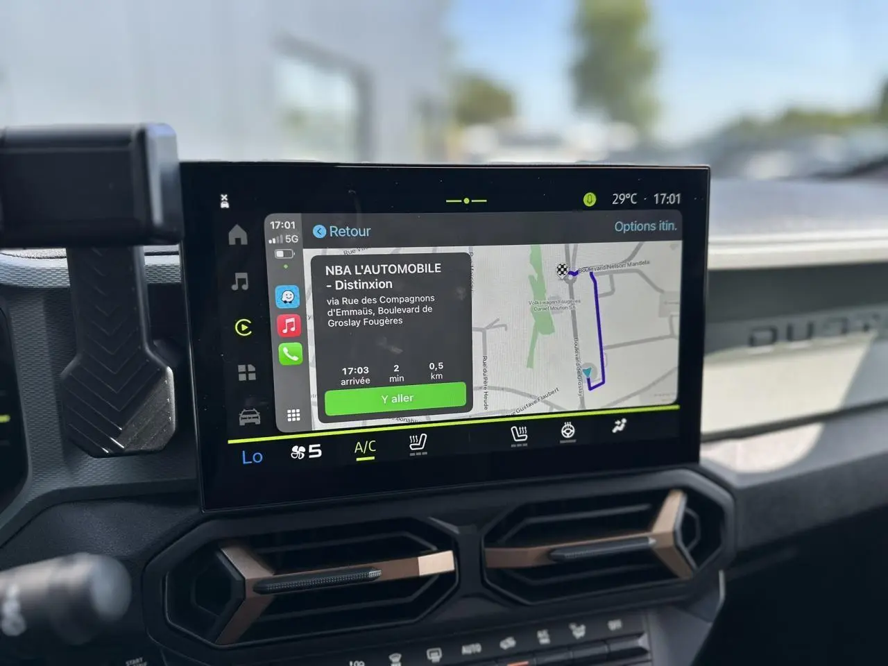 Écran tactile 10 pouces du tableau de bord du Dacia Duster 2025, avec navigation affichée, intérieur gris.