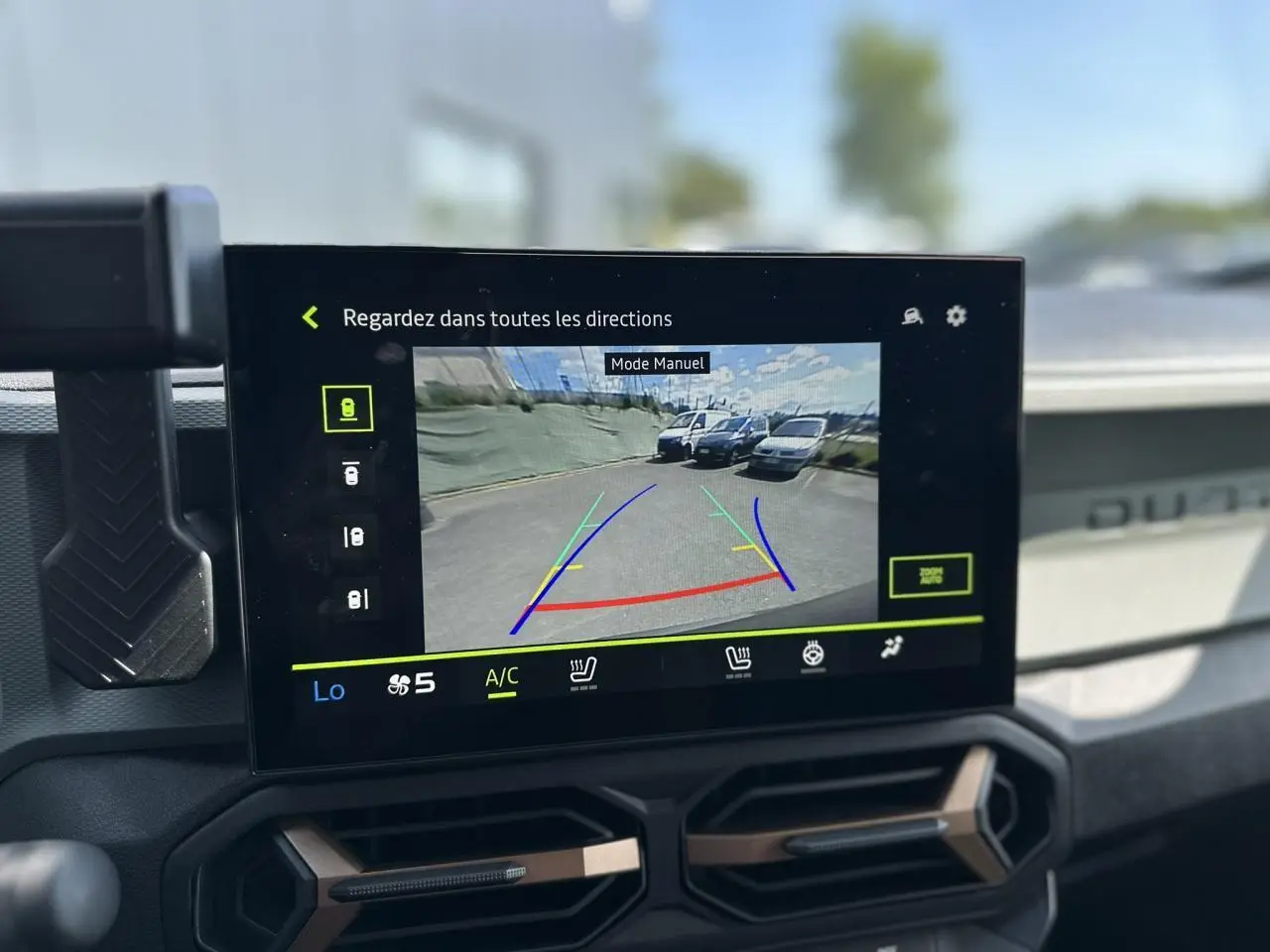 Écran tactile intérieur du Dacia Duster Gris Schiste 2025 montrant la caméra de recul avec guidage coloré.