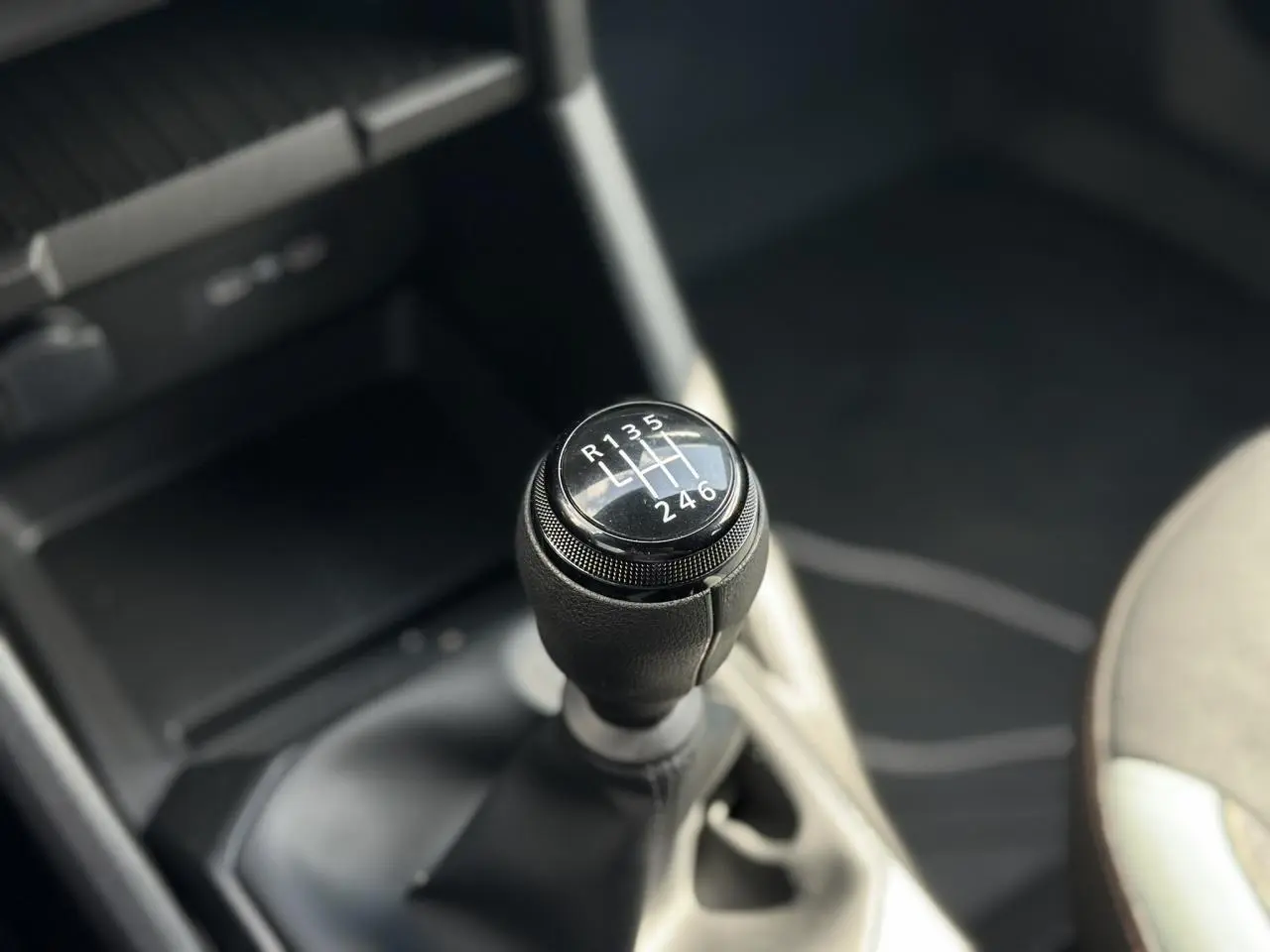 Gros plan sur le levier de vitesses manuel du Dacia Duster 2025, finition Gris Schiste, intérieur sombre.