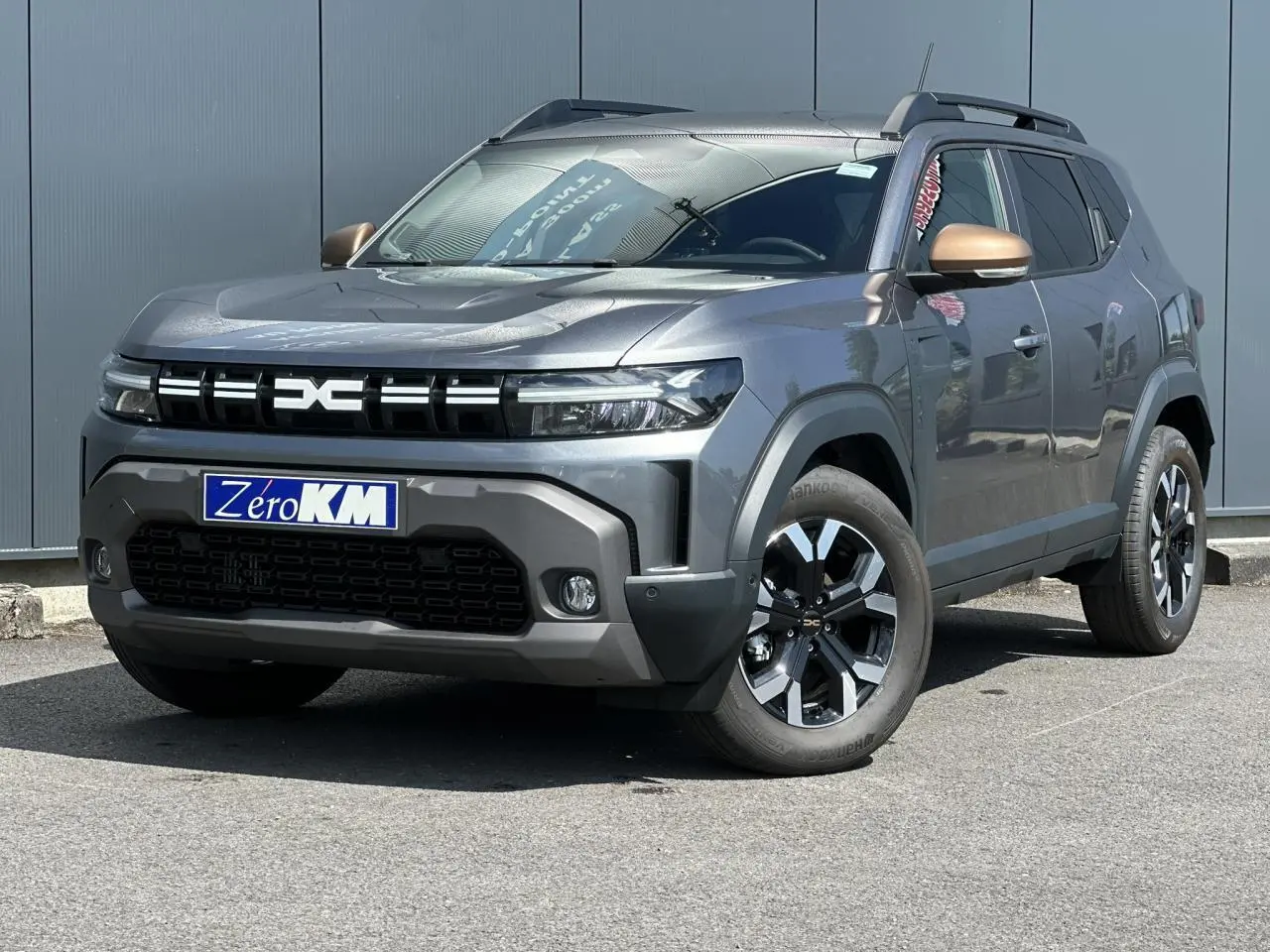 Dacia Duster ECO-G 100 Extrême gris schiste en 3/4 avant droit avec jantes alliage et rétroviseurs bronze.