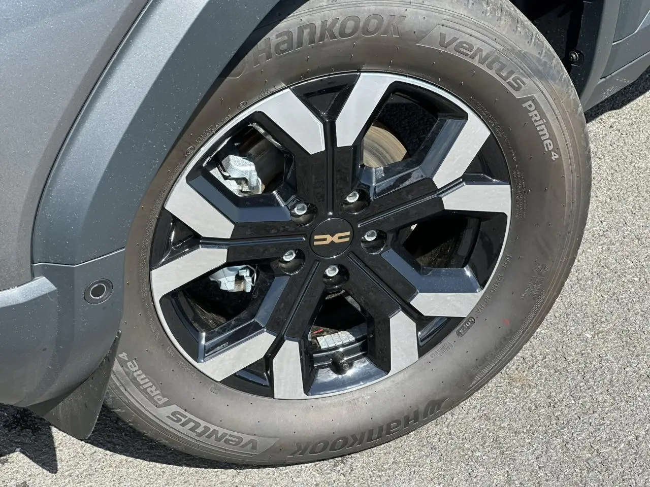 Gros plan sur la jante alliage 17 pouces semi-diamantée noire et grise du Dacia Duster Gris Schiste côté avant droit.