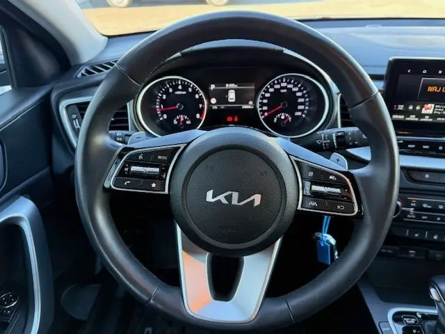 Vue centrée sur le volant de la Kia CEE'D 2024 essence, avec tableau de bord et commandes intégrées visibles.