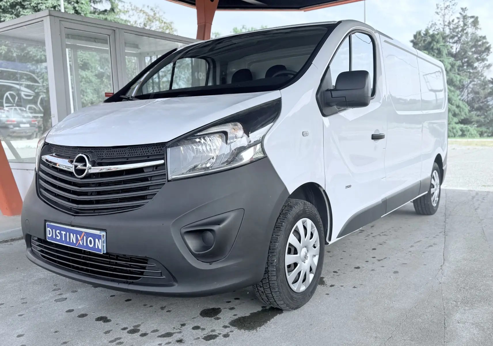 Vue 3/4 avant droit d’un Opel Vivaro blanc avec pare-chocs noir mat sous un abri extérieur.