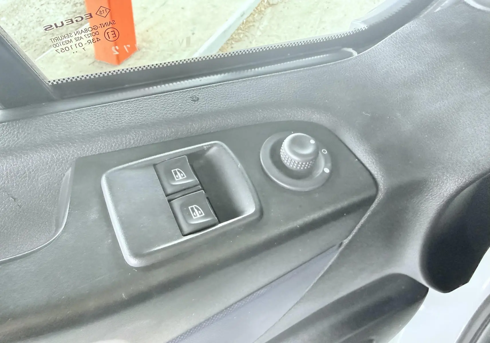 Gros plan sur les commandes de lève-vitres et réglage des rétroviseurs côté conducteur d’un Opel Vivaro blanc.