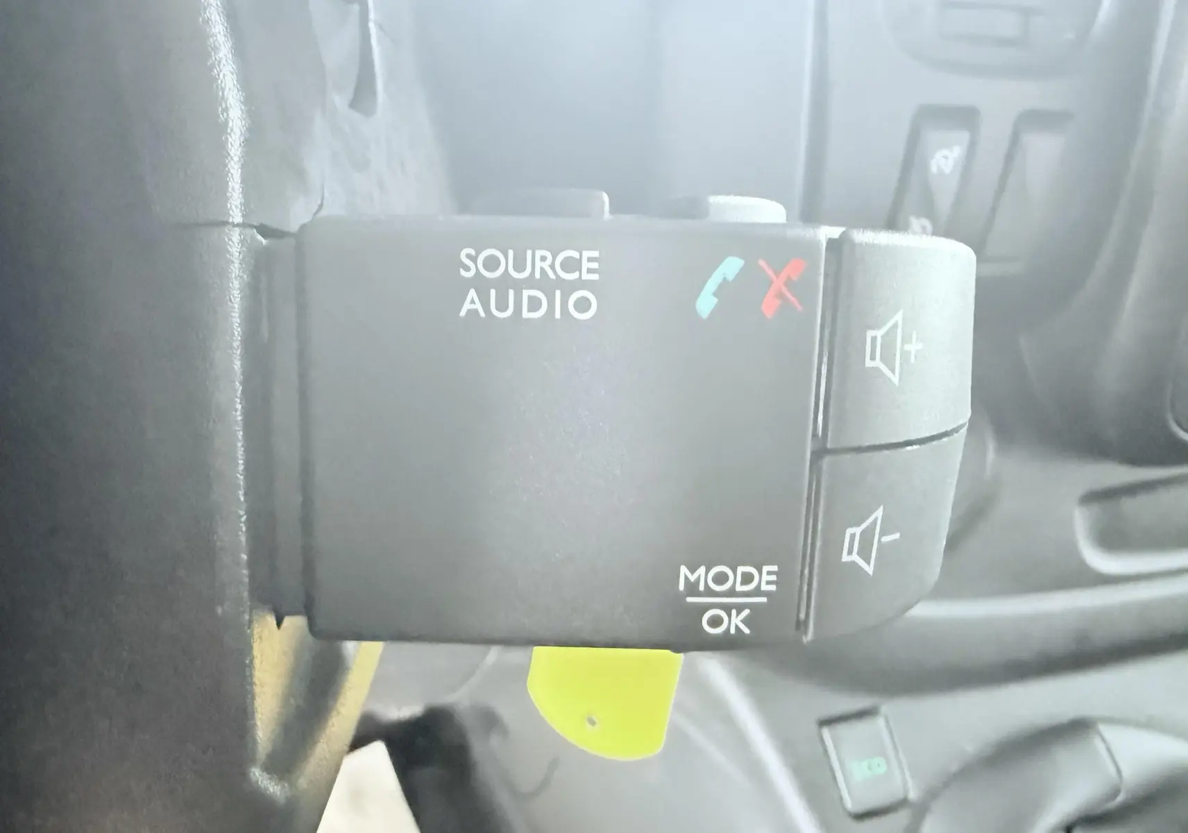 Gros plan sur la commande audio au volant du véhicule Opel Vivaro blanc, avec boutons de volume et fonctions appel.