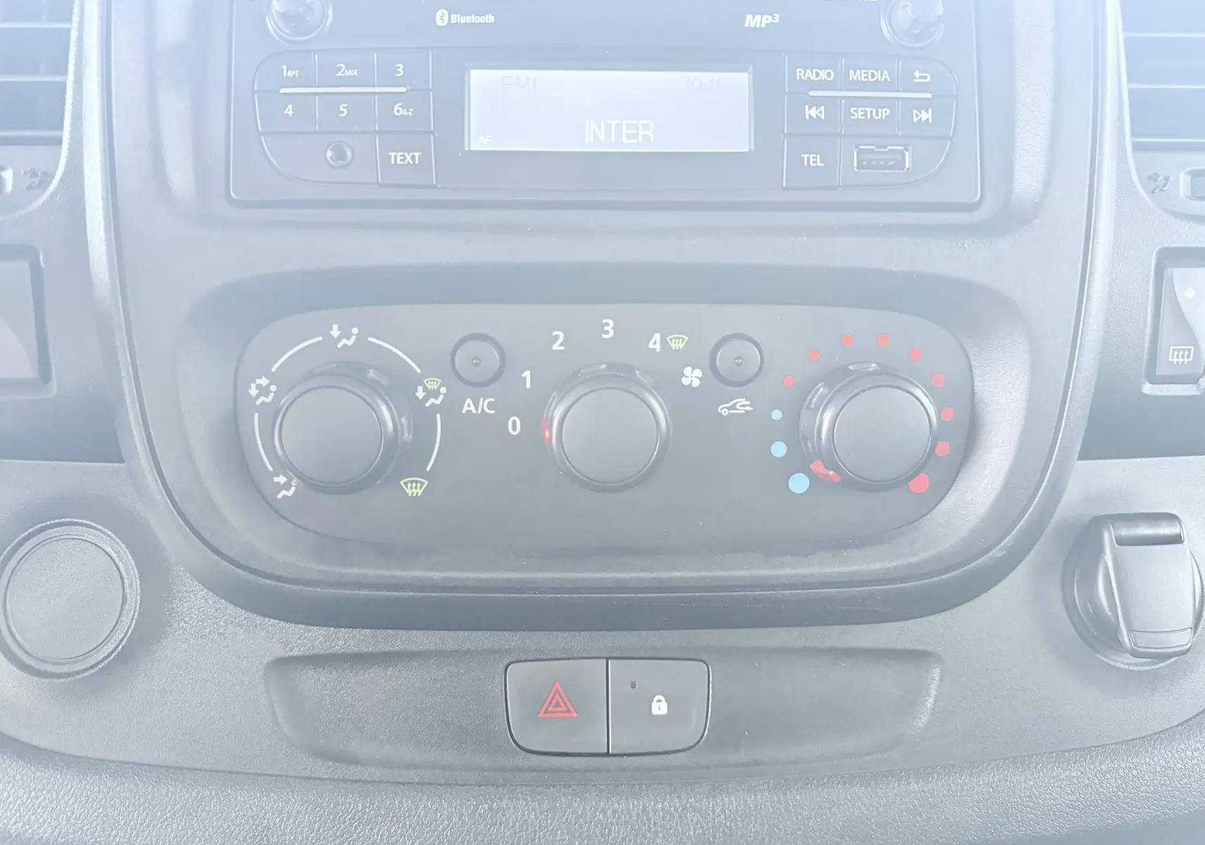 Vue rapprochée du tableau de bord de l'Opel Vivaro 2018 montrant les commandes de climatisation et la radio intégrée.