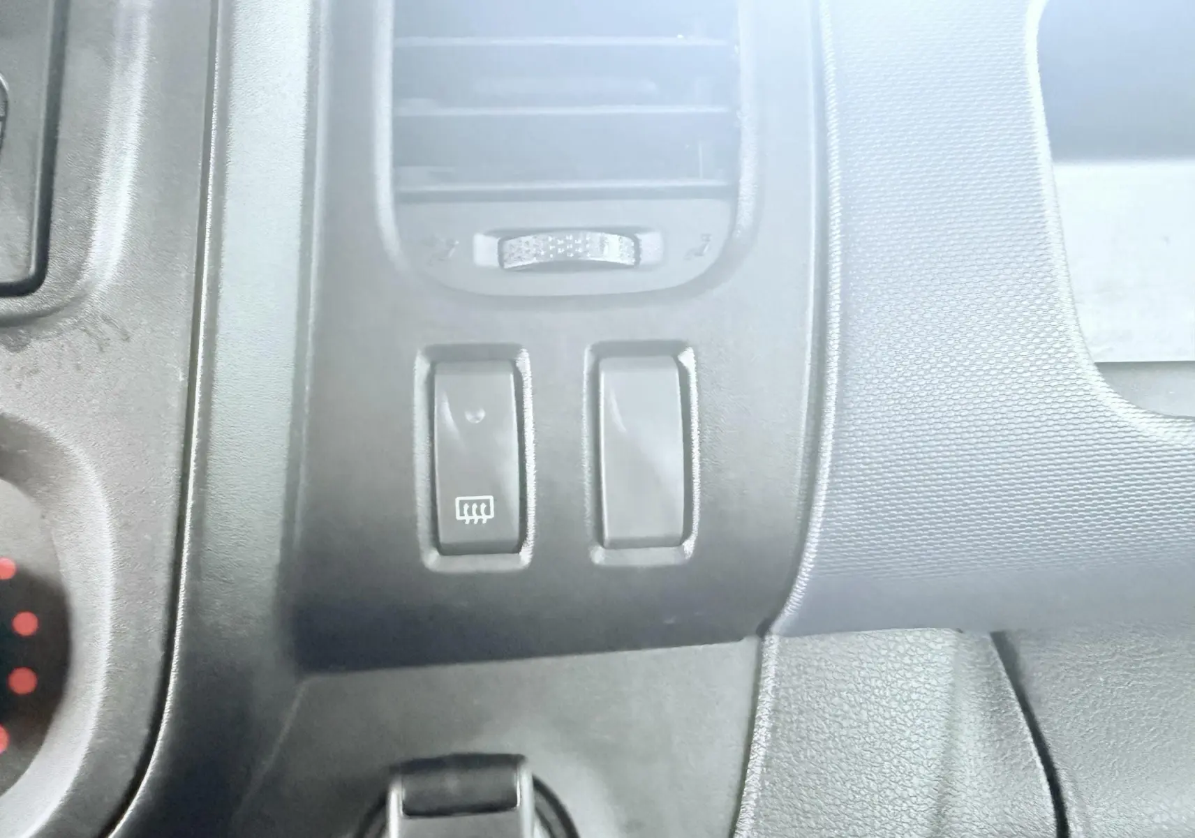 Détail du tableau de bord noir de l’Opel Vivaro 2018 montrant les boutons de dégivrage et ventilation.