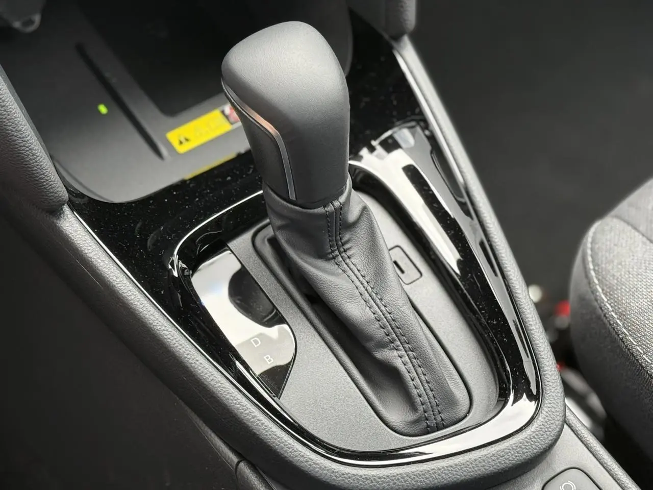 Gros plan sur le levier de vitesses automatique noir brillant de la Toyota Yaris Cross 1.5 Hybrid 116 Design.
