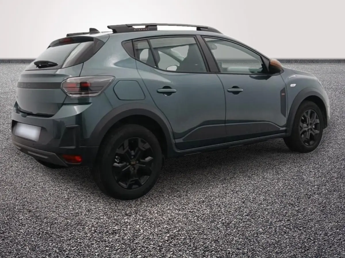 Vue 3/4 arrière droite d'une Dacia Sandero Extreme Eco-G 120 auto 2026 en vert avec jantes noires et barres de toit.