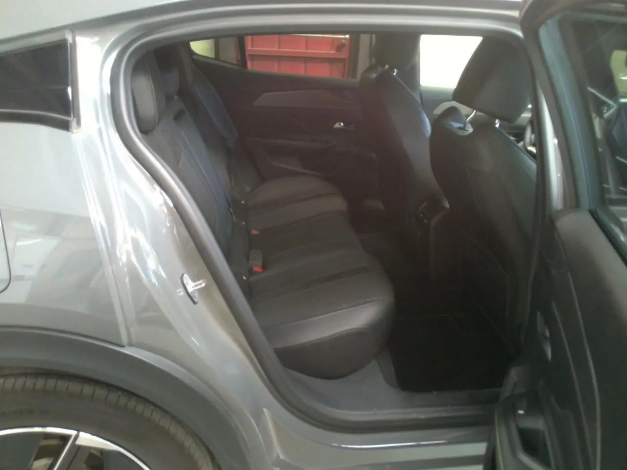 Vue côté gauche arrière du Peugeot 408 Hybrid 145 GT gris Selenium, montrant les sièges arrière en cuir noir.