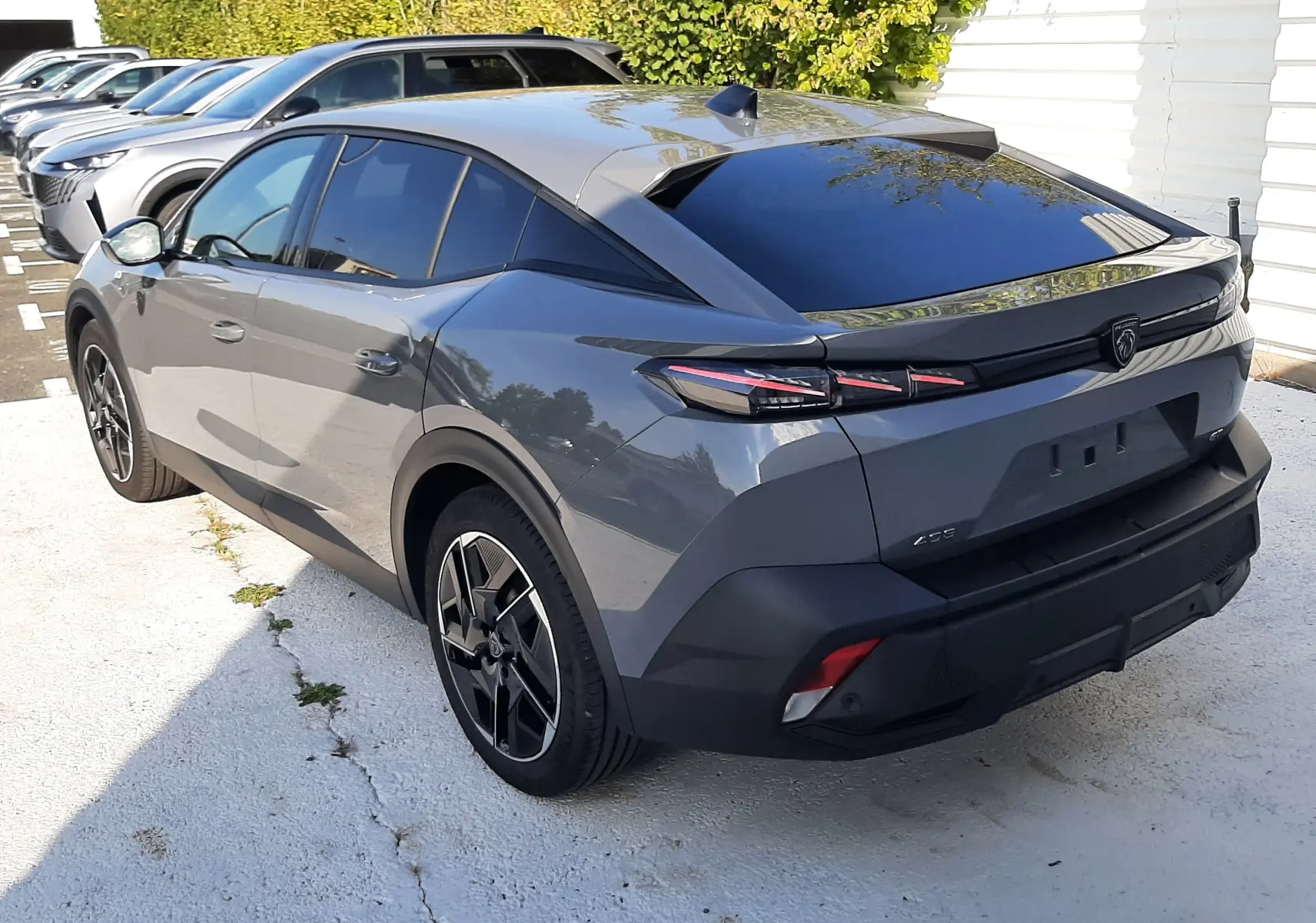 Vue 3/4 arrière droite d'une Peugeot 408 gris selenium avec feux arrière LED et toit noir brillant.