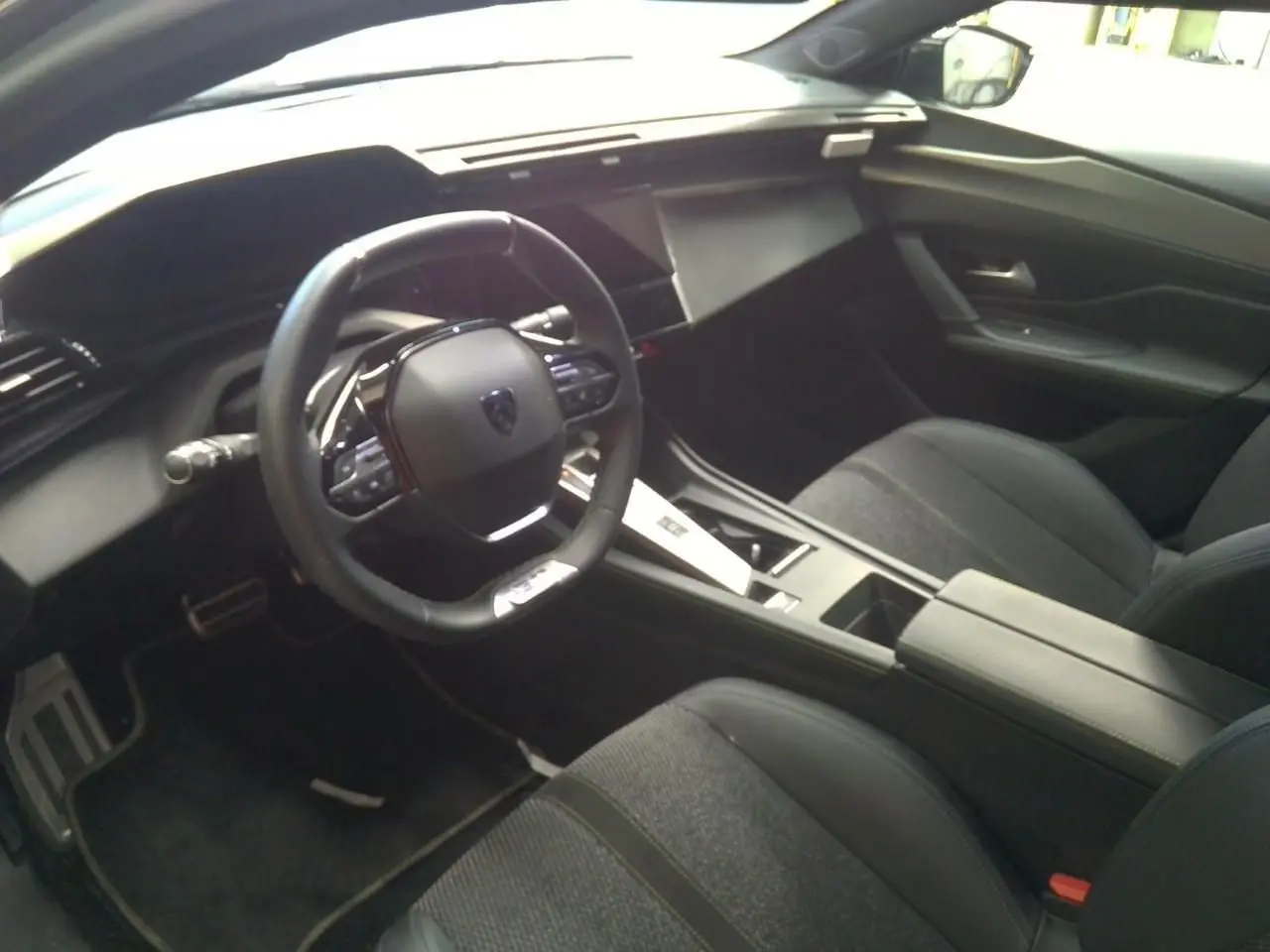 Vue 3/4 avant droit de la Peugeot 408 gris selenium avec rétroviseur noir brillant et jantes noires biton.