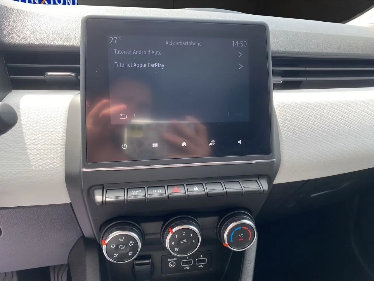 Écran tactile central affichant tutoriels Android Auto et Apple CarPlay dans l'habitacle noir de Renault Clio V 2023.