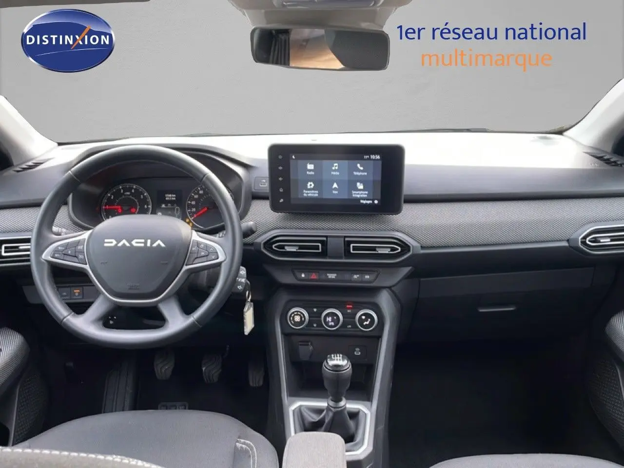 Vue intérieure frontale du tableau de bord noir du Dacia Jogger 2025 avec volant, écran tactile et boîte manuelle.