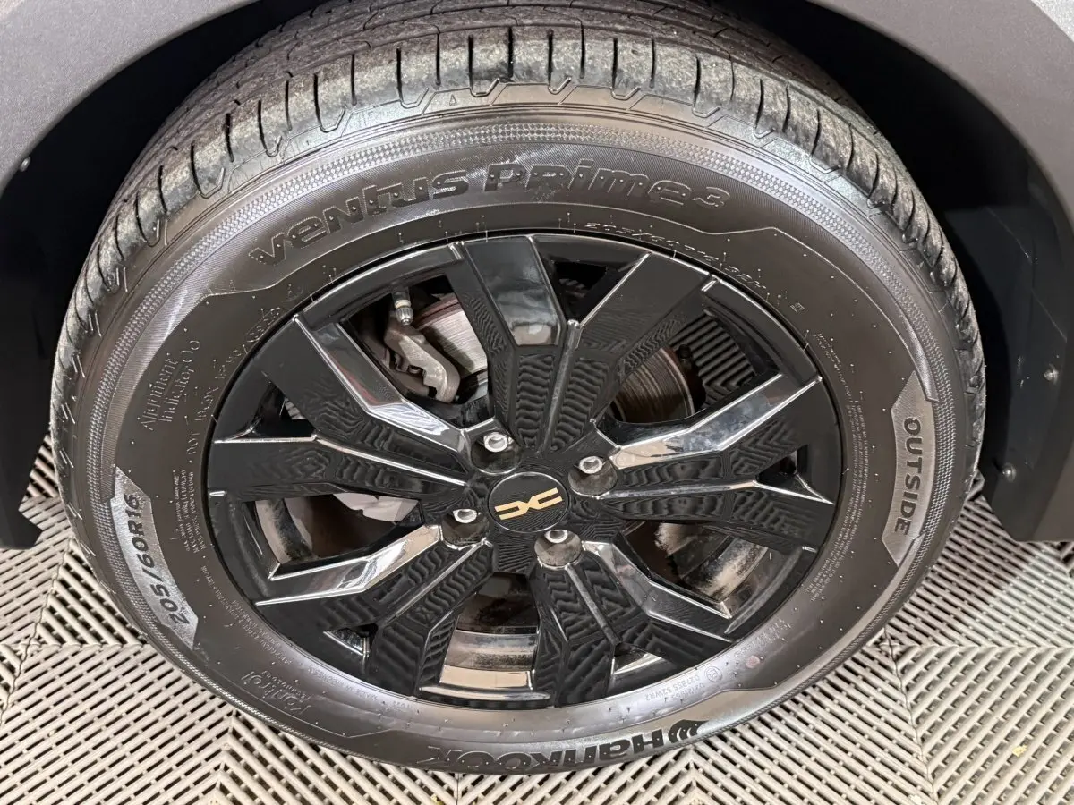 Gros plan sur la roue avant gauche noire à jante alliage du Dacia Sandero Extreme+ vert 2024.