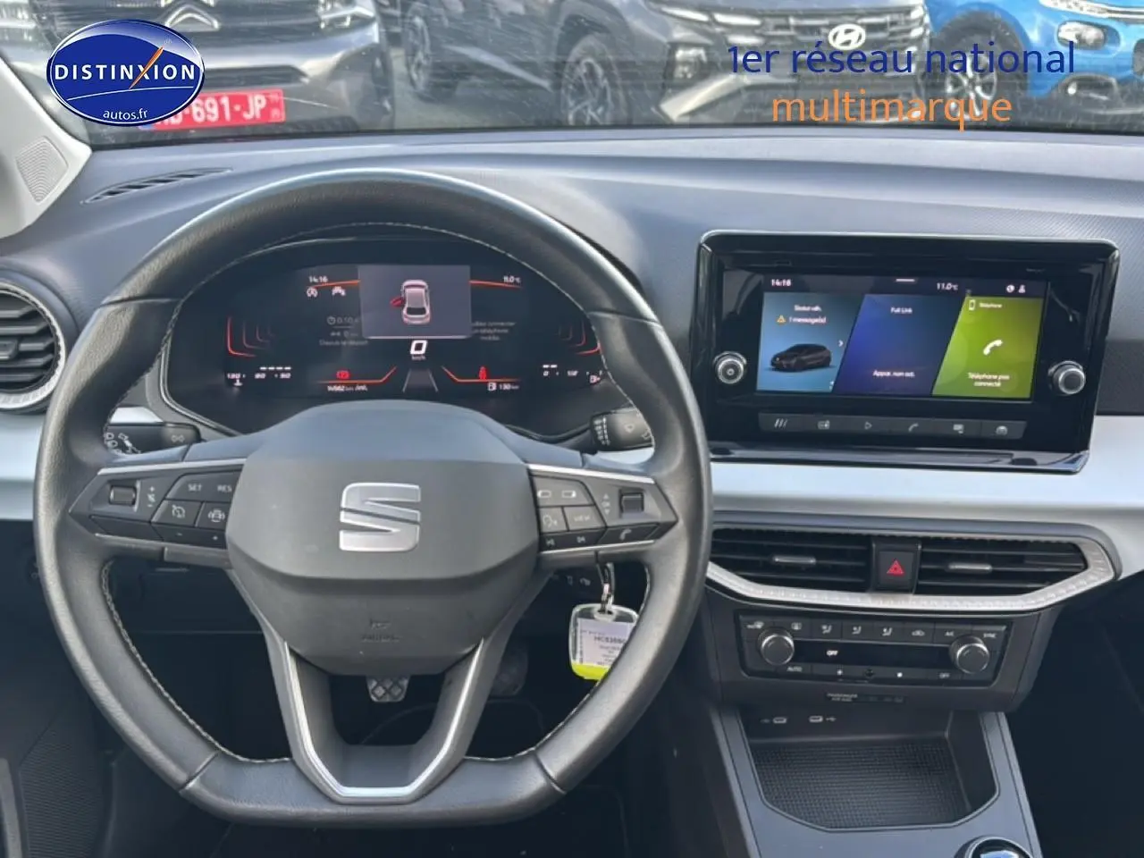 Vue intérieure centrée sur le volant cuir méplat et l'écran tactile HD du tableau de bord de la SEAT Ibiza gris magnétique.