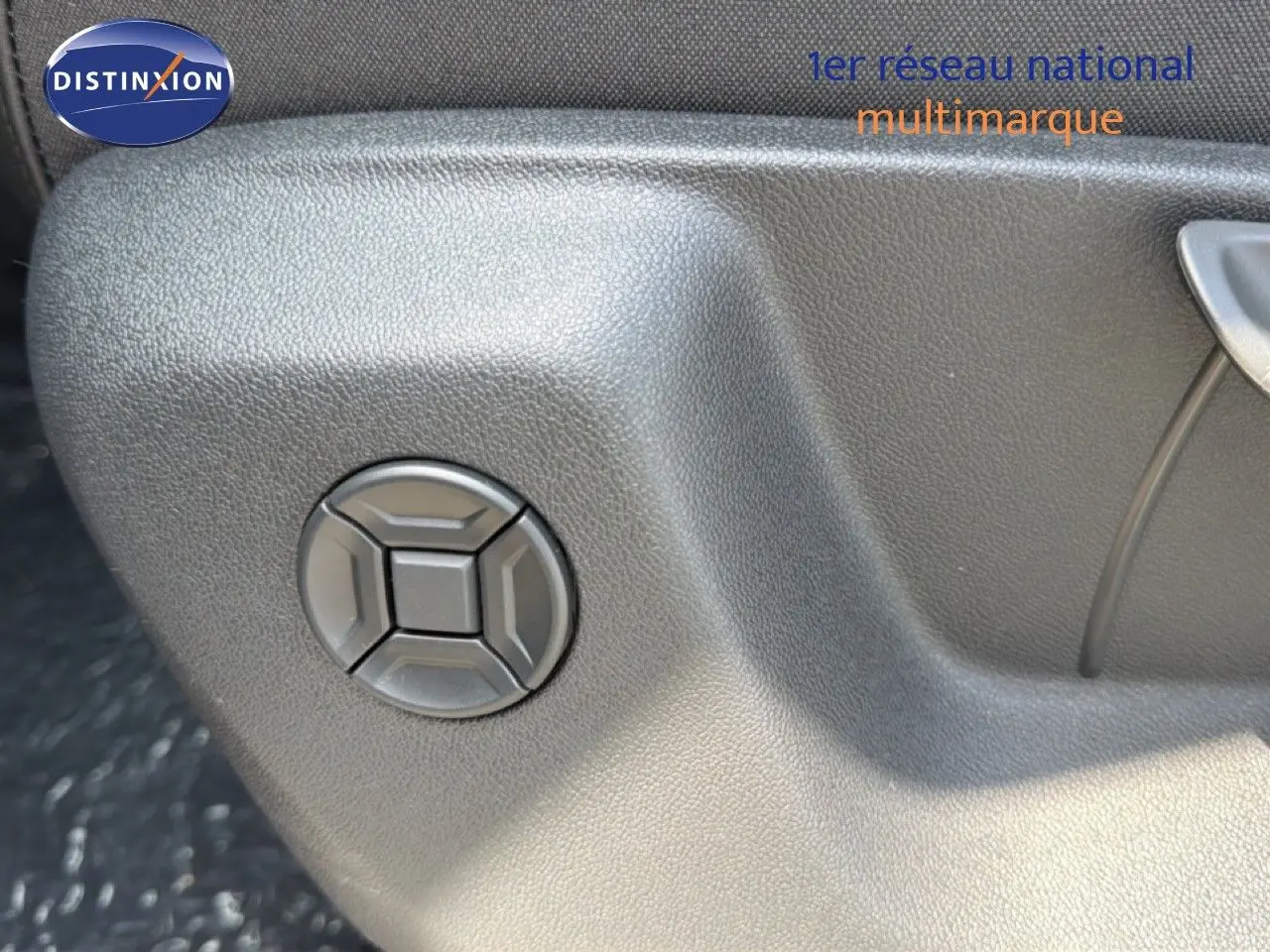 Détail du bouton de réglage de siège sur la portière intérieure d’un Volkswagen Tiguan gris dauphin métal.