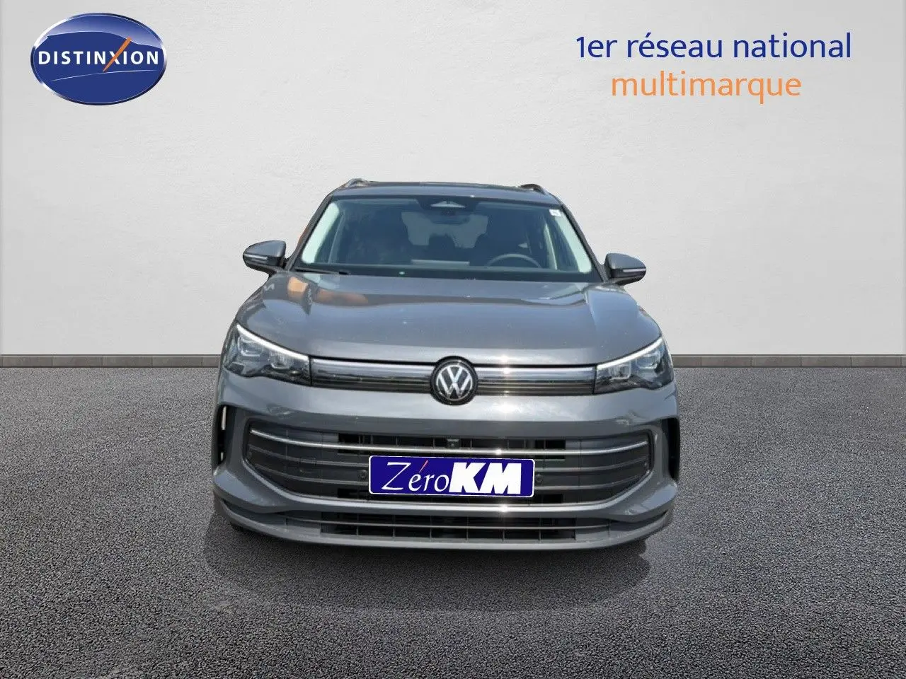 Vue avant d'un Volkswagen Tiguan gris dauphin métal 2026 avec calandre large et logo VW centré.