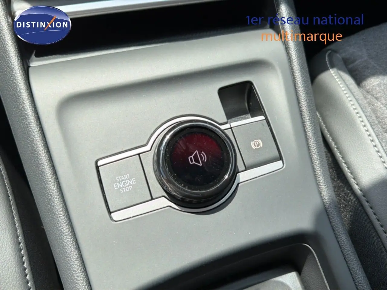 Gros plan sur la console centrale grise du Volkswagen Tiguan 2026, avec bouton start/stop et commande volume circulaire.