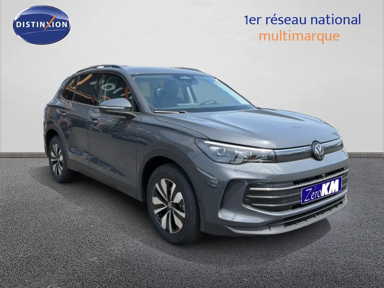 Volkswagen Tiguan gris dauphin métal en 3/4 avant droit avec calandre moderne et jantes bi-ton.